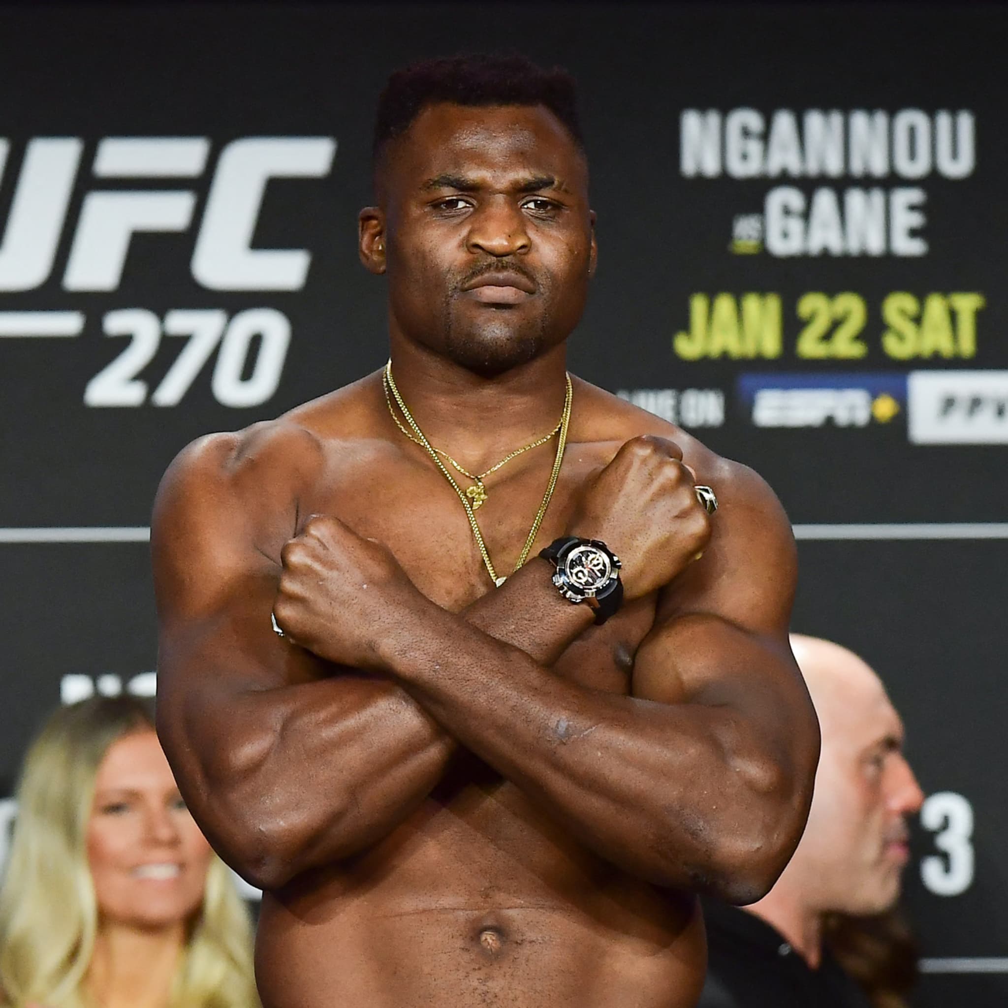 Francis Ngannou à la pesée de l'UFC 270 (Ngannou vs Ciryl Gane, 22 janvier 2022), bras croisés, chaines en or, regard intense devant le panneau UFC — portrait emblématique de l'ancien champion UFC des poids lourds avant sa rupture avec la PFL