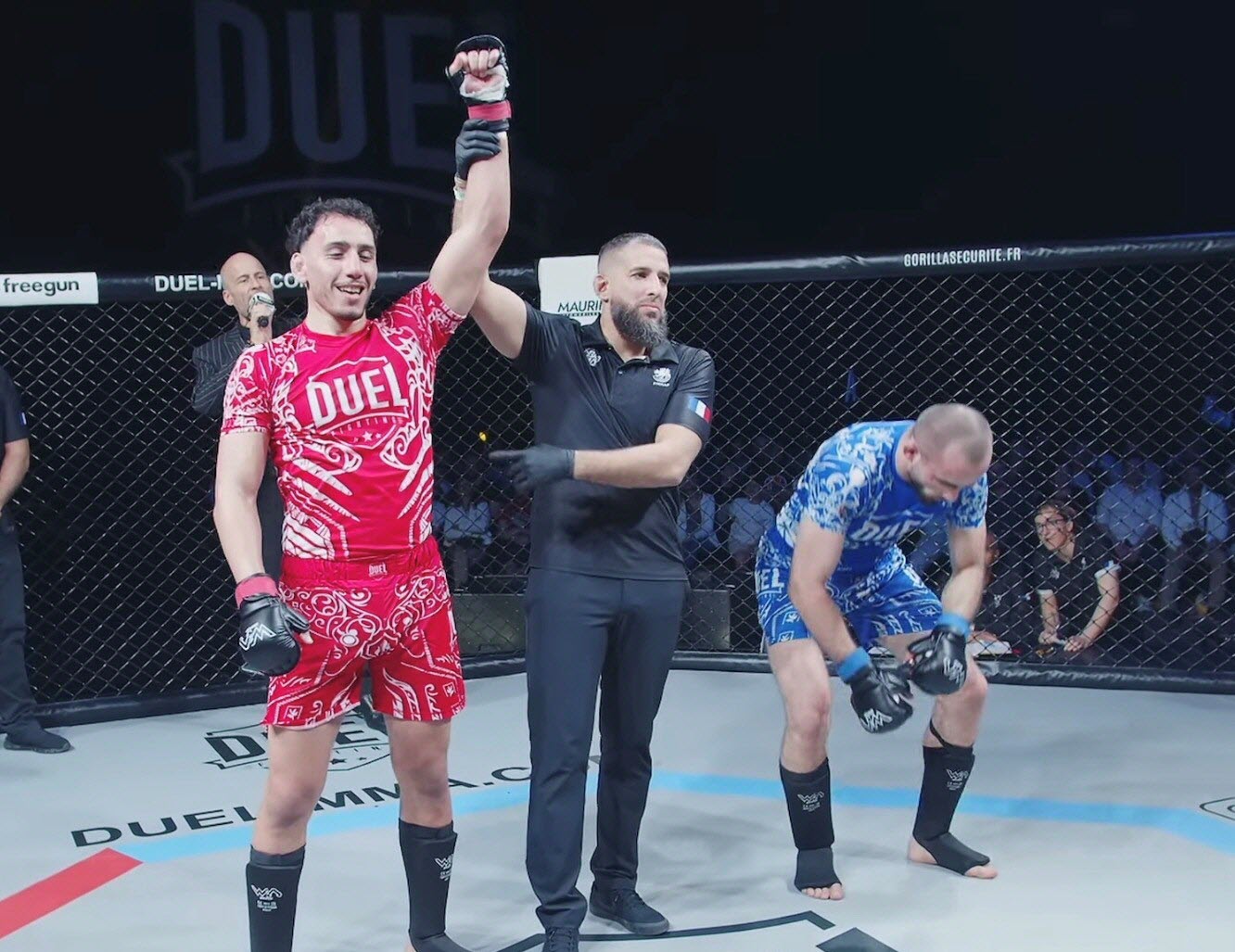Jessime Zouine bras levé après sa victoire en cage MMA - événement Duel